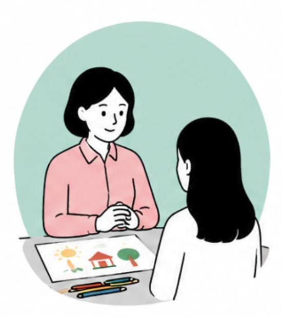 미술치료사와 한 사람이 그림을 함께 살펴보며 상담하는 장면